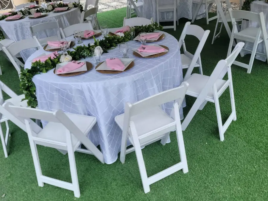 Guests gathered around an evening table beside a lit floral wall